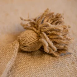 Housse de coussin en laine à pompons