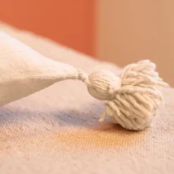 Housse de coussin en laine à pompons