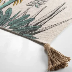 Tapis imprimé feuillages exotiques à pompons